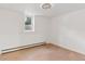 Basement room with light wood flooring, white walls, and a small window at 3775 S Forest Way, Denver, CO 80237