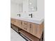Modern bathroom featuring double sinks, wood-look cabinets with open shelving and black hardware at 3775 S Forest Way, Denver, CO 80237