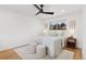 Cozy bedroom with a ceiling fan, accent rug, two ottomans, and a bedside table at 3775 S Forest Way, Denver, CO 80237