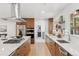 Open concept kitchen with an island, wooden cabinets, stainless steel appliances, and floating shelves at 3775 S Forest Way, Denver, CO 80237