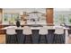 Bright kitchen boasts a large island with seating, floating shelves, and modern stainless steel appliances at 3775 S Forest Way, Denver, CO 80237