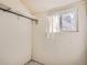 Basement room with a bright window with white curtain and an installed clothing rack at 1253 N Quitman St, Denver, CO 80204