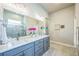 Bright bathroom with double sink vanity with modern fixtures, a large mirror, and stylish tile flooring at 12574 Lake View St, Longmont, CO 80504