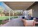 Inviting back porch with string lights and comfortable seating overlooking the spacious, green backyard at 9742 Burntwood Ct, Highlands Ranch, CO 80126