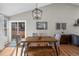 Dining area featuring a wooden table, bench, chairs, modern light fixture, and sliding door at 9742 Burntwood Ct, Highlands Ranch, CO 80126