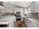 Updated kitchen featuring white cabinets, stainless appliances, quartz countertops and tile backsplash at 9742 Burntwood Ct, Highlands Ranch, CO 80126