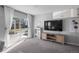 Bright living room featuring a modern entertainment center and sliding glass doors to the backyard at 9742 Burntwood Ct, Highlands Ranch, CO 80126