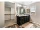Bright bathroom with double vanity sinks, large mirror, and walk-in closet at 11761 Cord Grass Way, Parker, CO 80138
