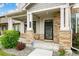 Inviting front porch features stone pillars, providing a welcoming entrance to the charming two-story home at 11761 Cord Grass Way, Parker, CO 80138
