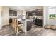 Modern kitchen featuring a large island with seating, stainless steel appliances, and dark cabinetry at 11761 Cord Grass Way, Parker, CO 80138