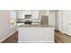 Modern kitchen features stainless steel appliances, white cabinetry, and a center island with sink at 2986 Oxley St, Strasburg, CO 80136