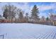 Large, snow-covered backyard featuring a wooden fence and bare trees in a winter setting at 3091 S Krameria St, Denver, CO 80222