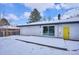 Backyard with a snow covered deck, patio doors and a white-brick house, with a bright yellow door at 3091 S Krameria St, Denver, CO 80222