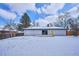 A well-maintained white-brick home with a covered patio and sliding glass door overlooks a snow-covered backyard with a wooden fence at 3091 S Krameria St, Denver, CO 80222