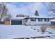 Charming single-story home with a two-car garage, fresh paint, landscaped front yard, and a snow covered lawn at 3091 S Krameria St, Denver, CO 80222