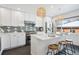 Modern kitchen with stainless steel appliances, a breakfast bar with seating, and stylish lighting at 3091 S Krameria St, Denver, CO 80222