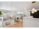 Open-concept living area flowing into a modern kitchen with sleek white cabinets and stylish dining space at 3091 S Krameria St, Denver, CO 80222