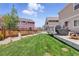 Lush backyard with a well-maintained lawn, wooden fence, and a spacious deck with a grill for outdoor cooking at 1673 Morningview Ln, Castle Rock, CO 80109