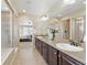 Spacious bathroom featuring double sinks, dark wood cabinets, and a large shower, with bedroom view at 1673 Morningview Ln, Castle Rock, CO 80109
