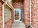 Close-up of the red brick exterior with a decorative front door and trim at 18338 E Powers Pl, Centennial, CO 80015