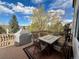 Outdoor deck featuring a table and chairs set, covered grill, and exterior view of trees at 18145 E Weaver Ave, Aurora, CO 80016