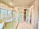 Modern bathroom featuring a glass enclosed shower with patterned tile and a separate soaking tub under a large window at 18145 E Weaver Ave, Aurora, CO 80016