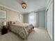 Bedroom with beige patterned wall and carpet, a bed with floral bedding and a decorative chandelier at 18145 E Weaver Ave, Aurora, CO 80016