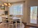Bright dining room with hardwood floors, white chairs, decor lighting, and direct access to the deck at 18145 E Weaver Ave, Aurora, CO 80016