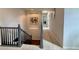 Hallway featuring carpet floors and a railing leading to the hardwood stairs with a metal artwork in the wall at 18145 E Weaver Ave, Aurora, CO 80016