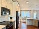 Modern kitchen with stainless steel appliances, island with sink, and view into the dining area at 18145 E Weaver Ave, Aurora, CO 80016
