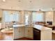 Bright kitchen featuring an island with sink, hardwood floors, fireplace, and access to a dining room at 18145 E Weaver Ave, Aurora, CO 80016