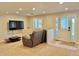 Living room with a recliner sofa, flat screen TV, and a glass door with a patterned privacy film at 18145 E Weaver Ave, Aurora, CO 80016