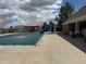 Fenced pool with a cover, complemented by a waterslide, poolside furniture, and partial view of the community at 18145 E Weaver Ave, Aurora, CO 80016