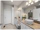Bathroom featuring double sinks, white cabinetry, tiled floor, and modern lighting at 20162 E 53Rd Pl, Denver, CO 80249