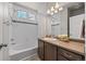 Well-lit bathroom with a shower-tub combo and dark wood vanity at 20162 E 53Rd Pl, Denver, CO 80249