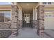 Inviting front porch featuring substantial stone columns, neutral siding and a glass front door at 20162 E 53Rd Pl, Denver, CO 80249
