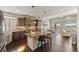 Open kitchen featuring a granite island with seating, modern stainless appliances, and views of a bright dining area and great room at 20162 E 53Rd Pl, Denver, CO 80249
