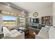 Bright living room with a large window, built-in shelves, stylish furniture, and dark hardwood flooring at 20162 E 53Rd Pl, Denver, CO 80249