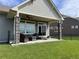 Covered patio with stone columns, ceiling fan, outdoor seating, and lush green lawn at 20162 E 53Rd Pl, Denver, CO 80249
