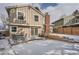 Back of home showing a large backyard featuring a patio, brick chimney, and tiered garden beds at 7801 S Hill Dr, Littleton, CO 80120