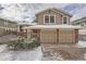 Charming home with a two-car garage, brick accents, and a well-maintained front yard during winter at 7801 S Hill Dr, Littleton, CO 80120