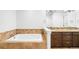 Luxurious bathroom featuring a soaking tub with tile surround, dark cabinets, and granite countertops at 1934 S Sherman St, Denver, CO 80210