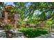 Lawn and garden in front of a red brick home featuring a second story terrace and wrought iron fencing at 1934 S Sherman St, Denver, CO 80210