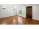 Bright living room with hardwood floors, white walls, a modern chandelier, and a dark wood front door at 1934 S Sherman St, Denver, CO 80210