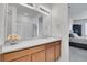 Bathroom vanity features a large mirror, bright lighting, and a white sink plus a shower and view to the bedroom at 10525 Akron St, Commerce City, CO 80640