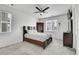 Bedroom with large windows, a ceiling fan, soft carpet and a dark wood bed frame and matching furniture at 10525 Akron St, Commerce City, CO 80640