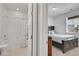 View into a bedroom and bathroom showcasing the bedroom's natural light and comfortable layout at 10525 Akron St, Commerce City, CO 80640