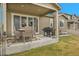 Covered patio area includes a dining table set, barbecue grill, and a sliding glass door to the home at 10525 Akron St, Commerce City, CO 80640