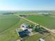 A panoramic view of a home surrounded by farmland, outbuildings, and a peaceful distant lake at 6331 County Road 32, Platteville, CO 80651