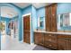 Spa-like bathroom with blue walls, a vanity with double sinks, and a walk-in closet at 6331 County Road 32, Platteville, CO 80651